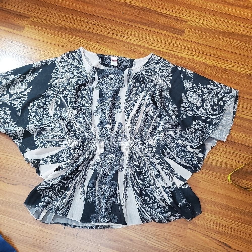 Rouge nude colored sheer club blouse q doleman sleeves and flounce waistline.